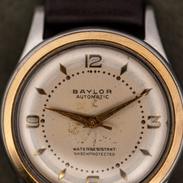 Baylor Automatic dial macro showing the printed BAYLOR AUTOMATIC signature, applied 12 and 3, and beaded minute track