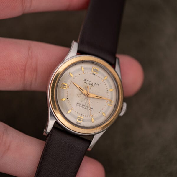 Baylor Automatic in hand showing the full dial, gilt dauphine hands and leather strap running to the lugs