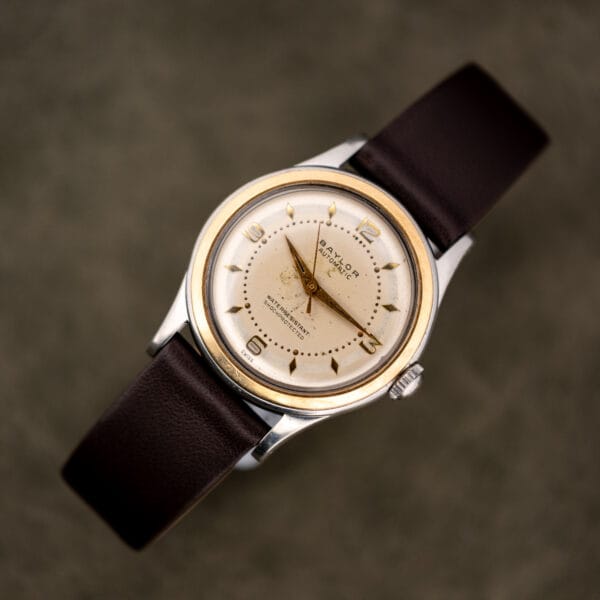 Top down view of the vintage Baylor Automatic laid flat on its leather strap, whole watch in frame