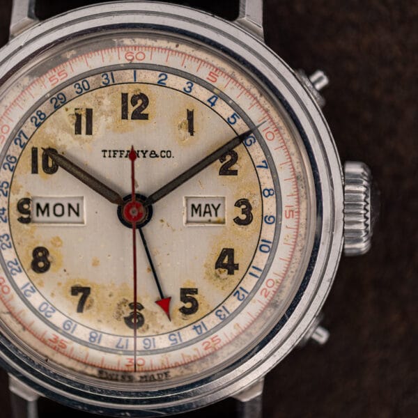 Tiffany & Co. signature printed below twelve on the Movado 14819 eggshell dial with MON and MAY calendar windows