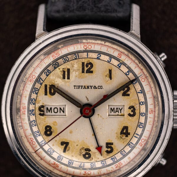 Movado 14819 dial macro showing the blue 1 to 31 date chapter, red fifth-second track and aged eggshell patina