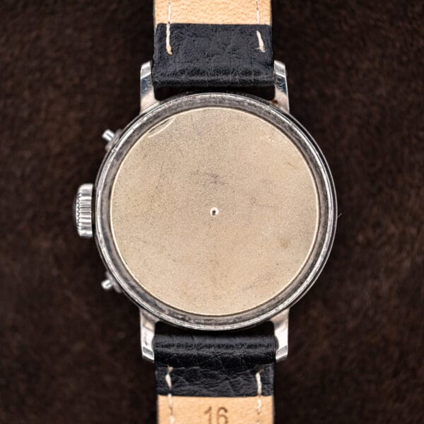 Movado 14819 with caseback removed, revealing the inner dust cover protecting the hand-wound movement