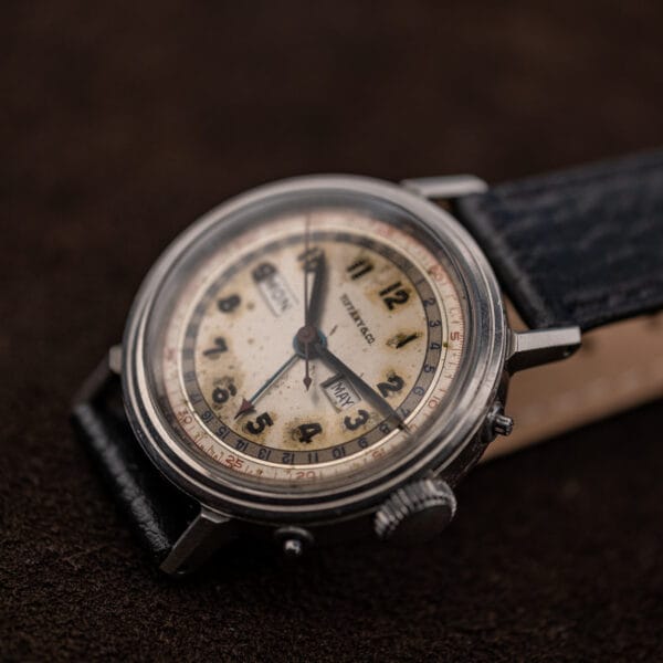 Movado 14819 at an angle showing both calendar pushers, the crown and the red-tipped date pointer hand