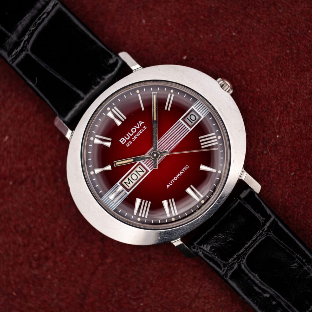 Bulova Day/Date T-3092 saucer case automatic, maroon vignette dial with day and date windows, black leather strap