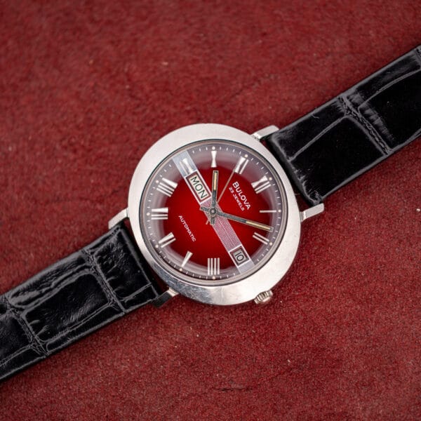 Vintage Bulova day/date automatic angled on velvet, polished stainless saucer case and alligator-grain leather strap