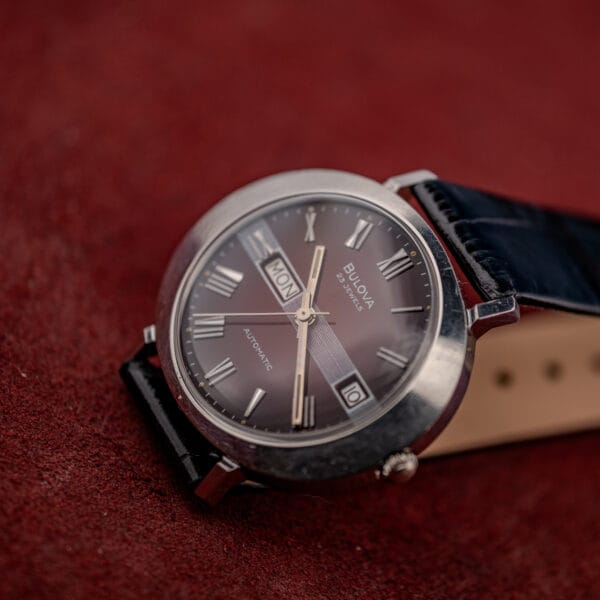 Bulova 23 Jewels automatic at a low angle where the maroon dial reads darkest toward the rim