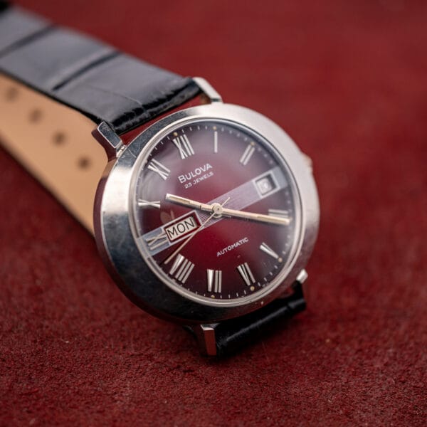 Vintage Bulova day/date automatic with the leather strap unbuckled, tan lining and Roman numeral chapter