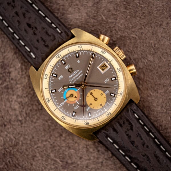 Overhead view of the cushion cased Omega Seamaster 176.007 on brown shark skin, whole mocha dial legible