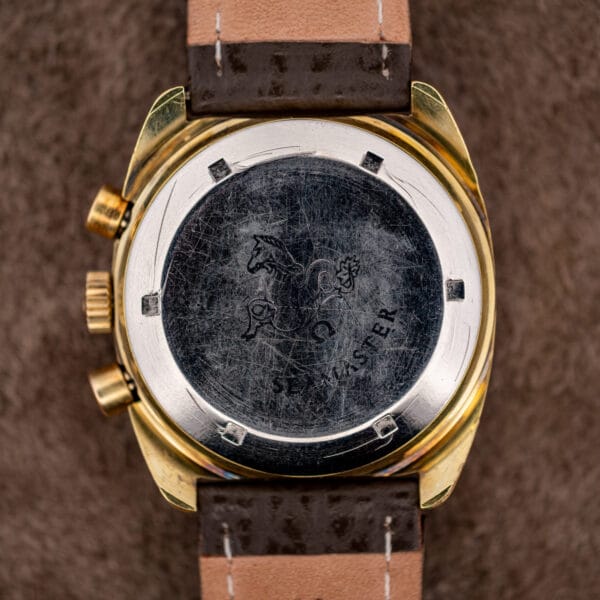 Reverse of the Omega 176.007 showing decades of hairlines across the stainless back and gold plated lugs