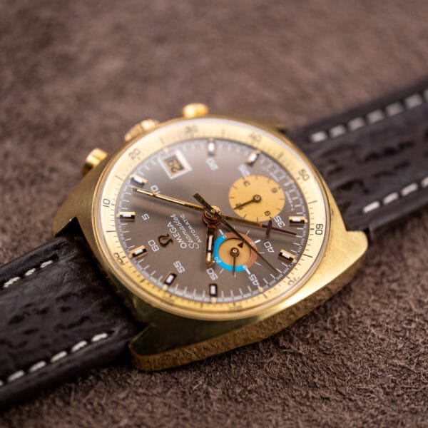 Omega Seamaster 176.007 tilted to catch the maroon cross tipped central minute hand crossing the mocha dial