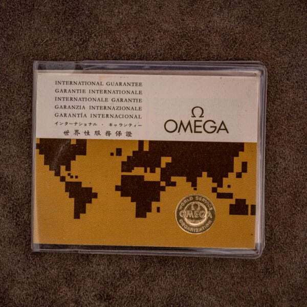 Omega International Guarantee wallet in several languages, gold World Service Organization seal on the world map