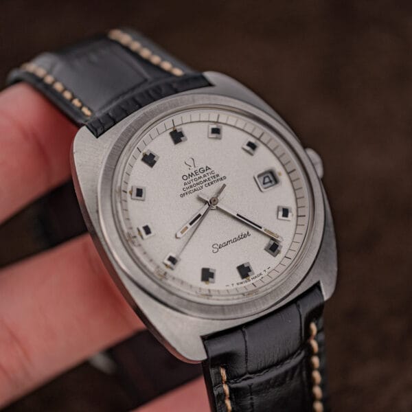 Omega Seamaster 168.035 three-quarter view in hand with the date in its framed window