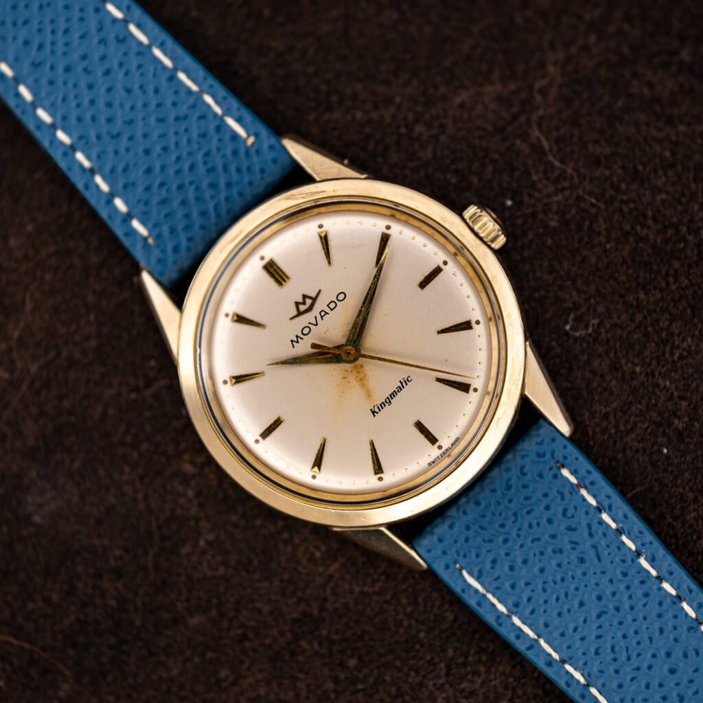 Vintage Movado Kingmatic automatic on a blue leather strap, white dial with applied gold markers