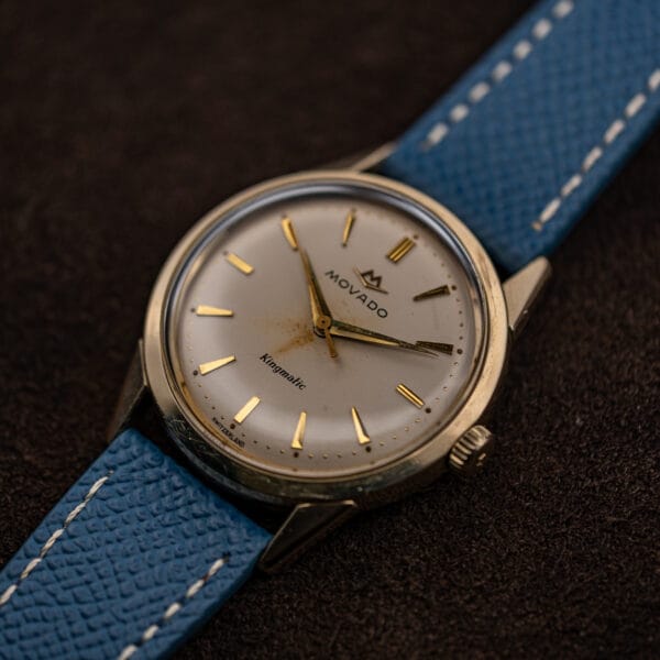 Angled view of the 14k gold filled Kingmatic case showing the domed crystal and tapered lugs
