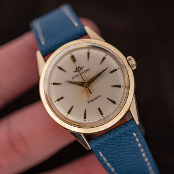 The Movado Kingmatic held in hand, showing its modest mid century case proportions