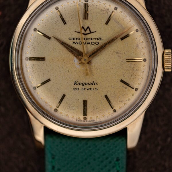 Movado Kingmatic champagne dial with triple line baton at twelve, gold dot minute track and fluted gold crown