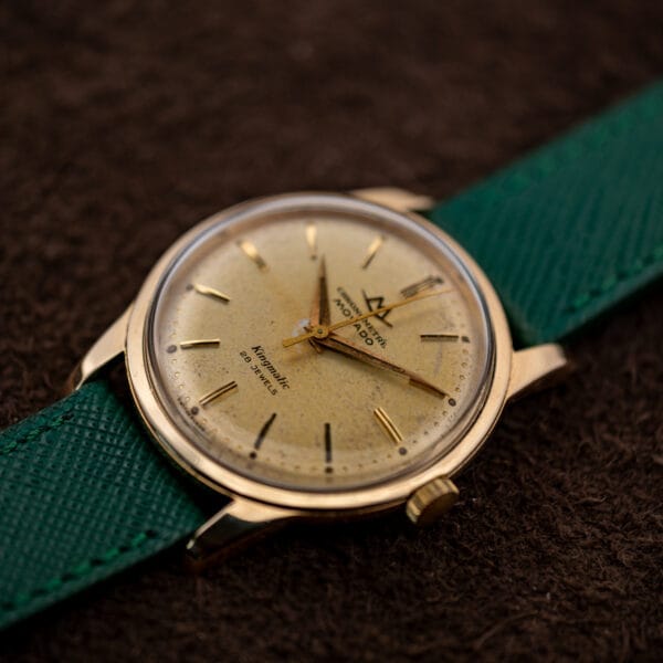 Movado Kingmatic dial angled to show applied gold batons, darkened lume plots and SWITZERLAND at the dial rim