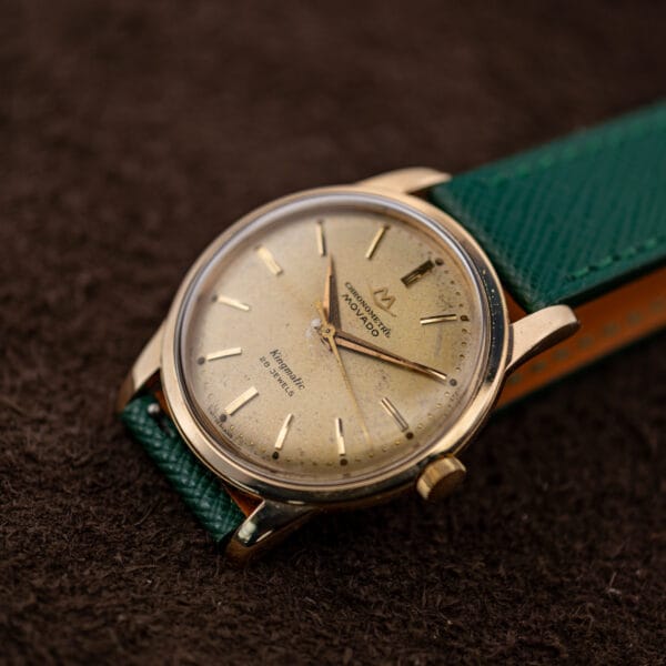 Vintage Movado Kingmatic 15072 on green saffiano strap showing 34mm gold capped case and speckled champagne dial