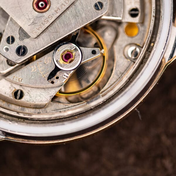 Movado Kingmatic balance wheel and hairspring macro with ruby shock setting and SWISS MADE on the rotor edge