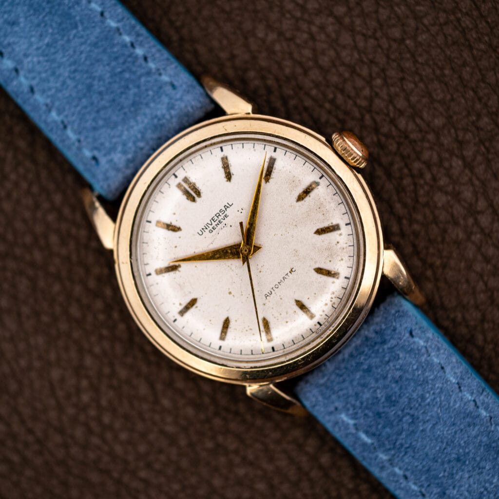 Universal Genève automatic with a white dial and gold dauphine hands on a powder blue suede strap