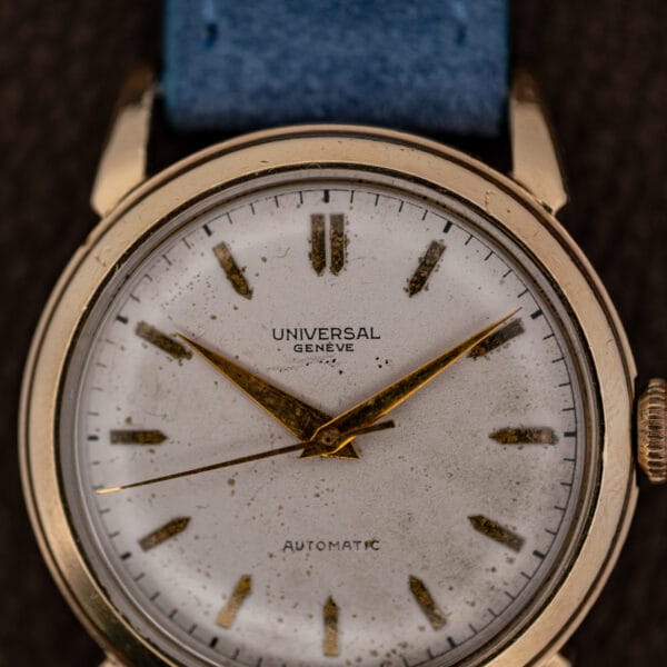 Close view of the UNIVERSAL GENÈVE dial showing applied gold batons and darkened luminous fill