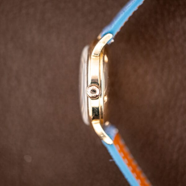 Side profile showing the reeded winding crown and the slim polished gold filled case band