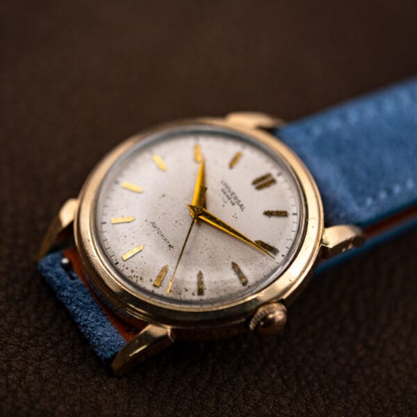 Three quarter view catching warm light across the 10k gold filled case and white dial