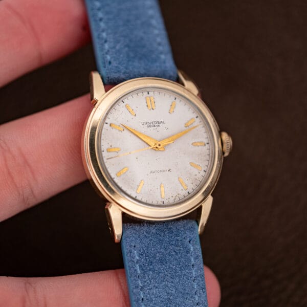 Held in hand, showing the case proportions of this Universal Genève against the fingers