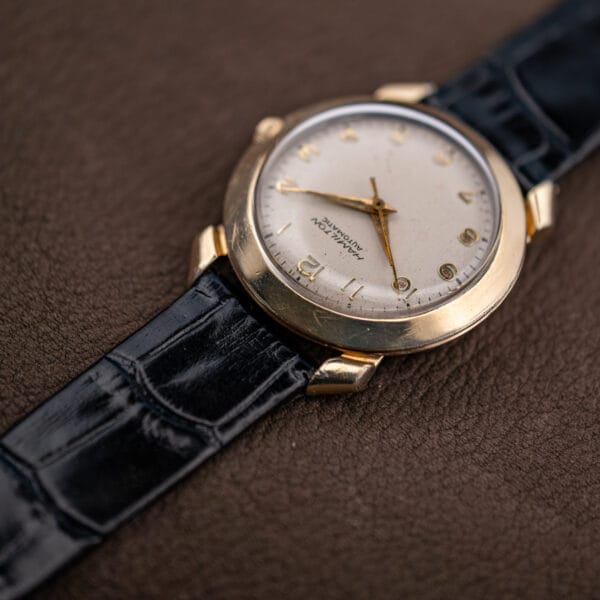 Angled view of the Hamilton K-455 showing hairline wear across the domed gold filled bezel