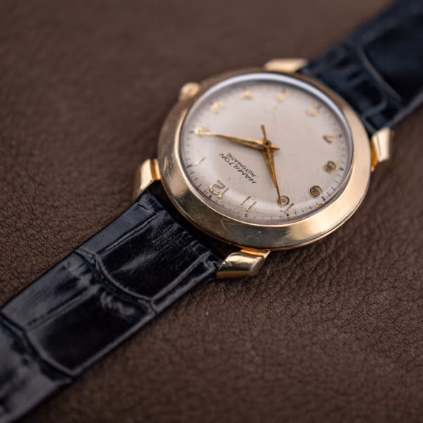 Angled view of the Hamilton K-455 showing hairline wear across the domed gold filled bezel
