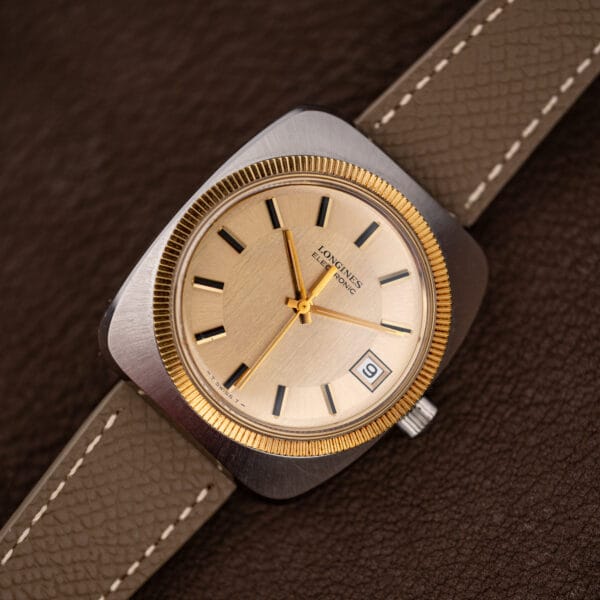 Close crop of the two-zone champagne dial, gold baton hands and sweep seconds hand