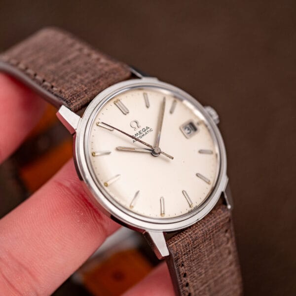 The slim steel case held in hand, white dial in natural light