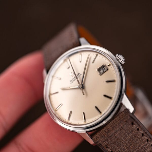 Hand-held three-quarter view showing the dial and aged lume plots