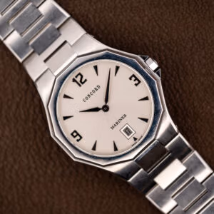 Concord Mariner 14.E7.1881 with silver sunburst dial and twelve-sided steel bezel on its integrated bracelet