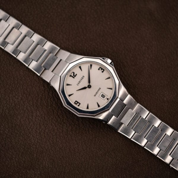 The full bracelet laid out flat, showing brushed outer links and polished center sections running to the case