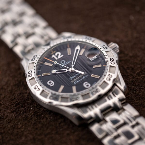 Omega Seamaster 196.1526 dial tilted toward the light, showing the wave guilloche pattern beneath the Omega logo.