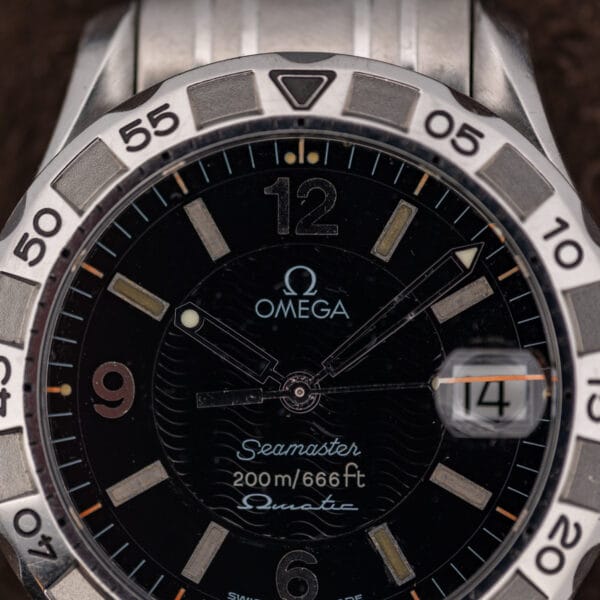Close macro of the dial text reading Seamaster, 200m/666ft and the Ωmatic script above six o'clock.