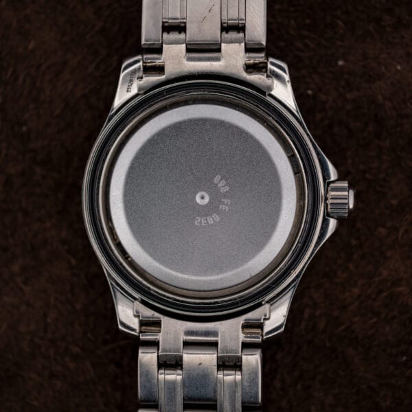 Caseback removed, revealing the movement still under its matte grey protective cover marked 096 FF and 0032.