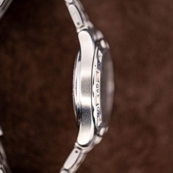 Opposite case flank of the Seamaster Autoquartz with the rotating bezel numerals catching light at forty five.