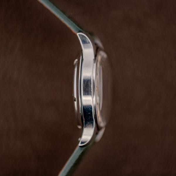 Nine o'clock flank of the Longines 6280-5 steel case, free of pushers, with downturned tapered lugs