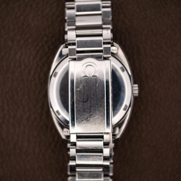 Omega bracelet clasp cover closed over the Constellation caseback, raised Omega symbol worn from decades of wear