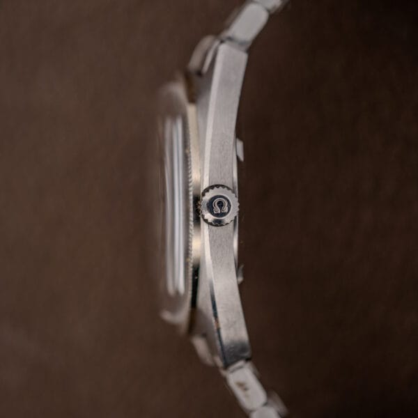 Omega signed fluted crown at three o'clock on the brushed stainless flank of the Constellation cushion case
