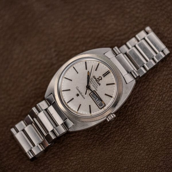 Vintage Omega Constellation day date on brown leather, crown toward lower right, bezel fluting catching the light