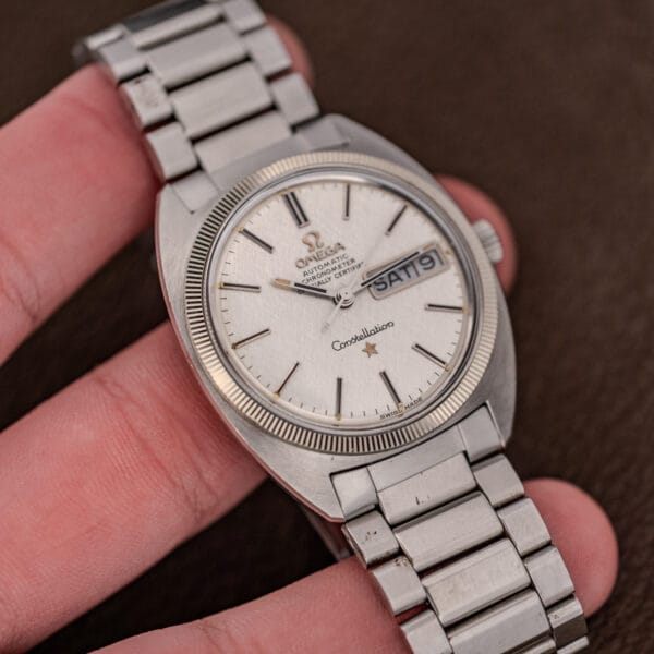 Vintage Omega Constellation 168.029 held in hand for scale, linen dial and day date window in view