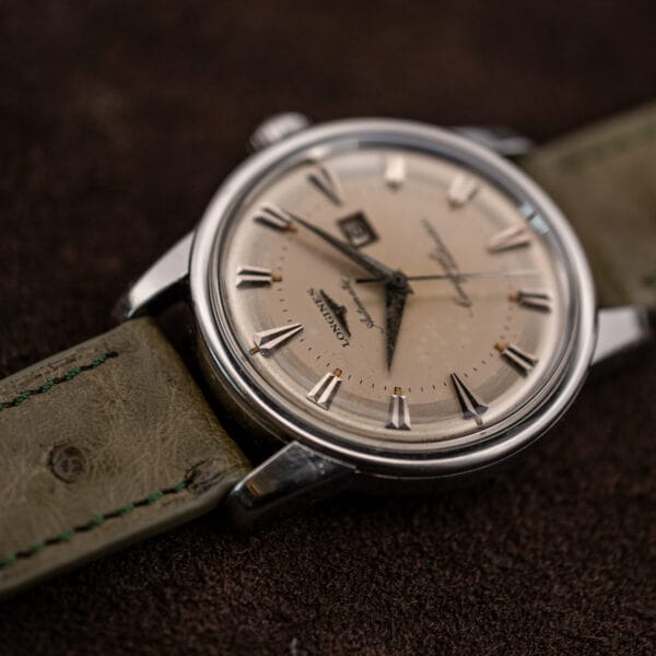 Low-angle view of the Longines 9004-3 emphasizing crystal dome, case profile and ostrich strap grain
