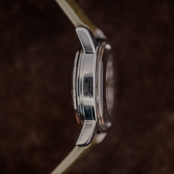Case profile from nine o'clock showing the domed crystal, polished band and gently downturned lugs