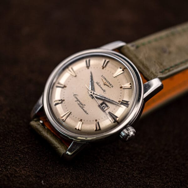 Hero angle of the Conquest Calendar 9004-3 with the olive ostrich strap's orange leather lining visible