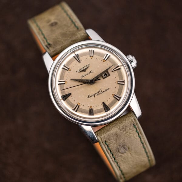 Eggshell dial tone, framed date window and aged tan lume on this Conquest Calendar 9004-3
