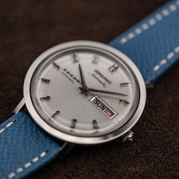 Low angle across the Longines Admiral dial showing the domed crystal profile and the dial recessed below a stepped flange