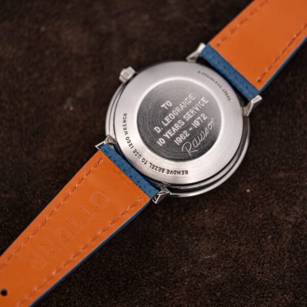 Three quarter Longines Admiral caseback stamped STAINLESS STEEL beside the presentation engraving and OTTUHR embossed strap lining